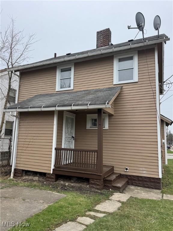 back of property featuring a porch, central air condition unit, and a chimney