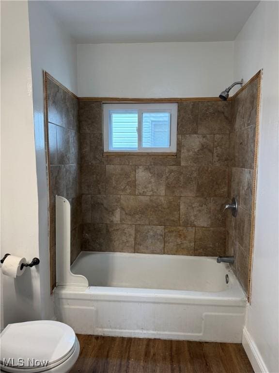 bathroom with toilet, baseboards, bathing tub / shower combination, and wood finished floors