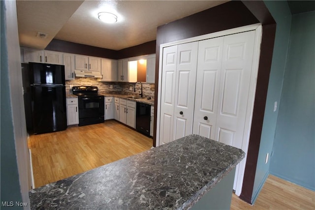 7073 Bristlewood Dr, Concord, OH 44077 - kitchen with black appliances, under cabinet range hood, a sink, light wood-style flooring, and white cabinetry