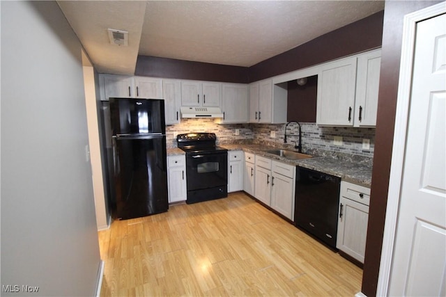 7073 Bristlewood Dr, Concord, OH 44077 - kitchen featuring black appliances, under cabinet range hood, a sink, backsplash, and light wood-style floors