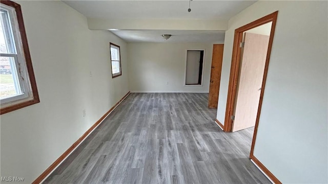 unfurnished room featuring baseboards and wood finished floors