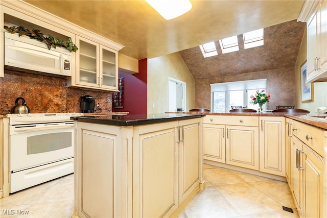 kitchen with cream cabinets, dark countertops, decorative backsplash, light tile patterned floors, and white electric range