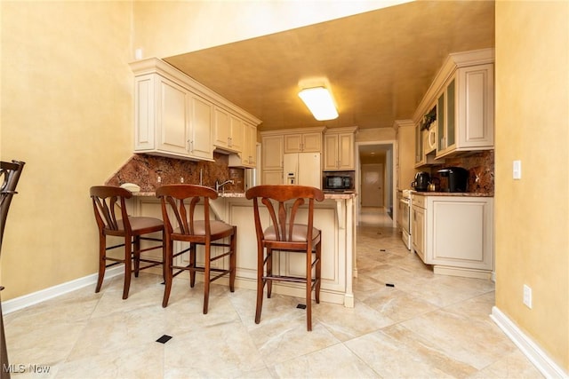 kitchen featuring decorative backsplash, a peninsula, black microwave, and white fridge with ice dispenser