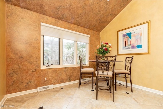 dining area featuring baseboards, visible vents, and lofted ceiling