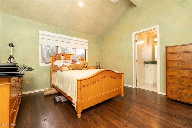bedroom featuring dark wood-style flooring, baseboards, vaulted ceiling, and ensuite bath