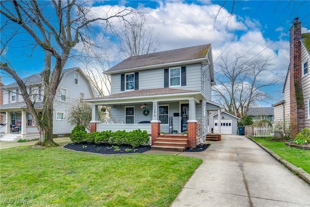 american foursquare style home featuring a front yard, roof with shingles, an outbuilding, a detached garage, and a porch