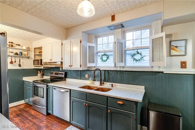 kitchen featuring a sink, stainless steel appliances, an ornate ceiling, and wainscoting