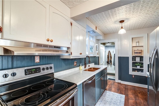 kitchen with an ornate ceiling, under cabinet range hood, a sink, white cabinets, and appliances with stainless steel finishes