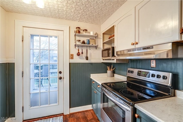 kitchen featuring light countertops, appliances with stainless steel finishes, under cabinet range hood, and an ornate ceiling