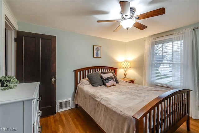 bedroom featuring visible vents, wood finished floors, and a ceiling fan