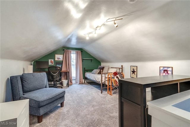 bedroom with track lighting, lofted ceiling, and light colored carpet