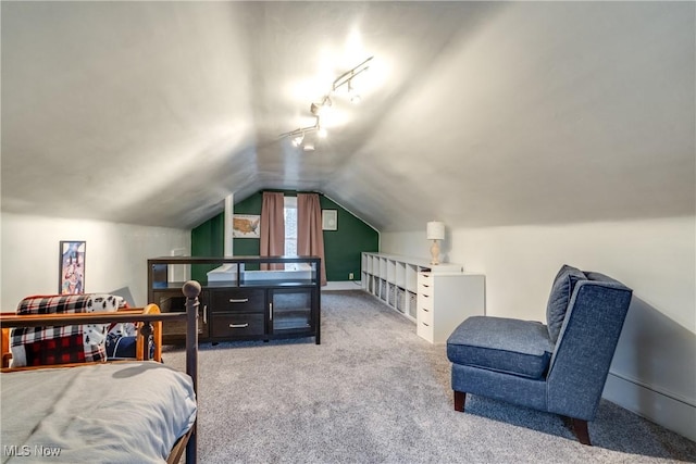 bedroom featuring vaulted ceiling, rail lighting, and carpet flooring