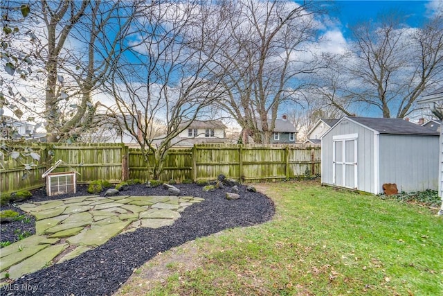 view of yard with a storage unit, a fenced backyard, and an outdoor structure