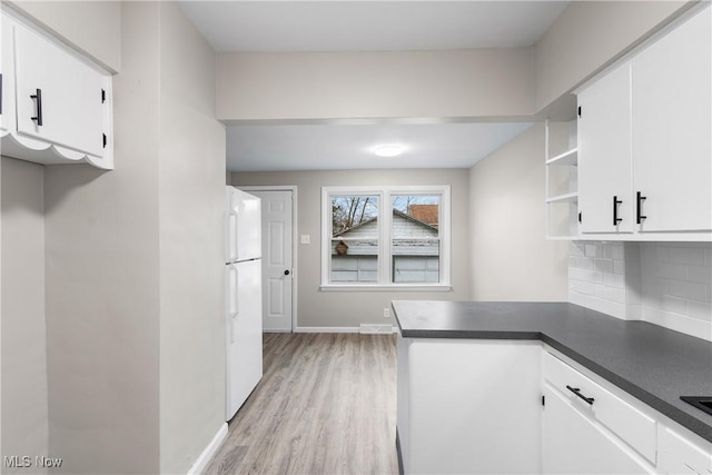 1862 17th St SW, Akron, OH 44314 - kitchen with freestanding refrigerator, dark countertops, white cabinetry, and backsplash