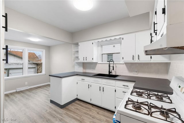 1862 17th St SW, Akron, OH 44314 - kitchen with visible vents, white gas range, dark countertops, a sink, and open shelves