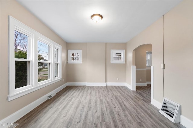 1862 17th St SW, Akron, OH 44314 - spare room with baseboards, visible vents, wood finished floors, and arched walkways