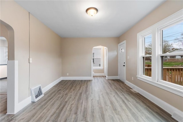 1862 17th St SW, Akron, OH 44314 - unfurnished room featuring baseboards, visible vents, wood finished floors, and arched walkways