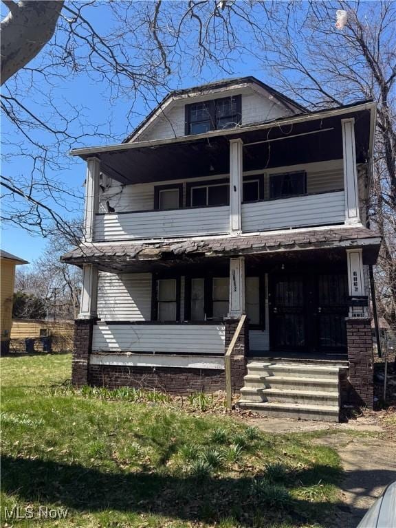 1136 E 145th St, Cleveland, OH 44110 - traditional style home featuring a balcony, covered porch, and a front lawn