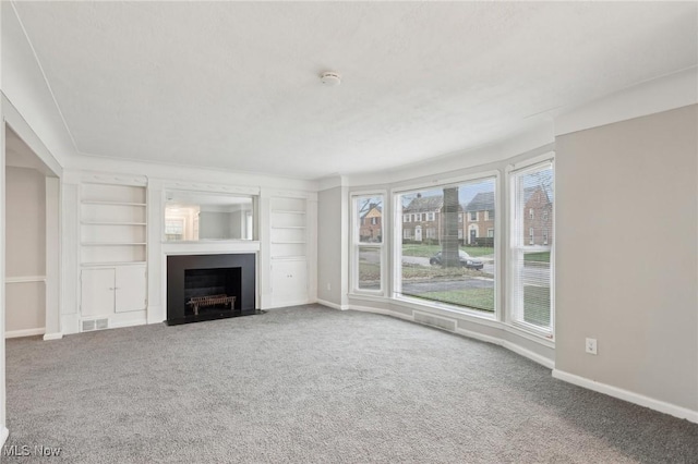 unfurnished living room with a fireplace with flush hearth, baseboards, visible vents, and carpet floors
