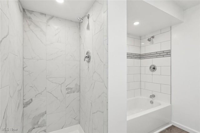 bathroom featuring baseboards and shower / bath combination