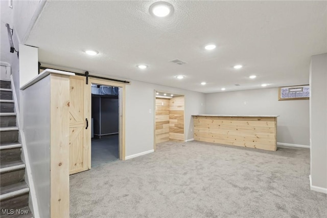 finished below grade area with stairs, visible vents, carpet floors, and baseboards