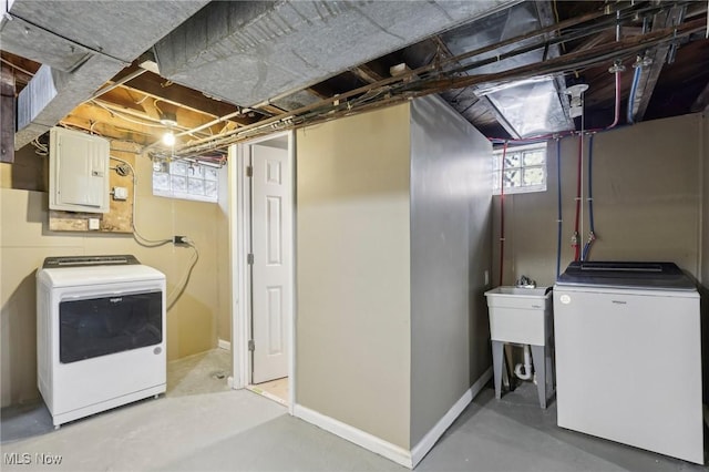 washroom featuring baseboards, laundry area, electric panel, and washer and dryer