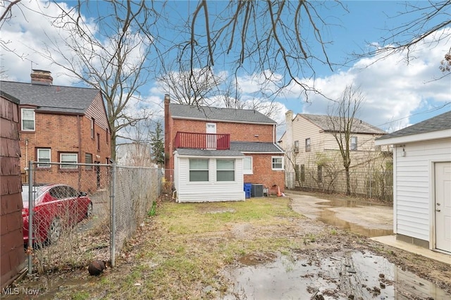 back of house featuring a fenced backyard and central AC