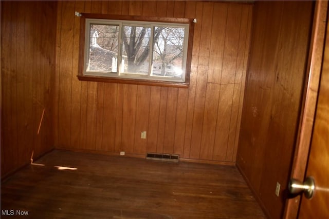 190 10th St, Campbell, OH 44405 - empty room featuring visible vents, wooden walls, and wood finished floors