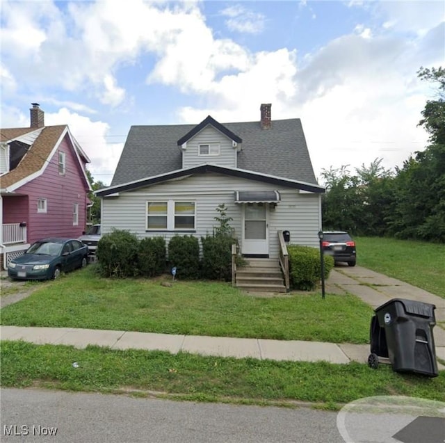 bungalow with a front lawn and concrete driveway