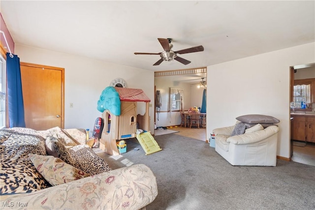 carpeted living room with ceiling fan
