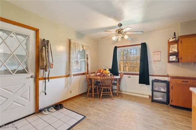 dining area featuring baseboards, ceiling fan, and light wood-style floors