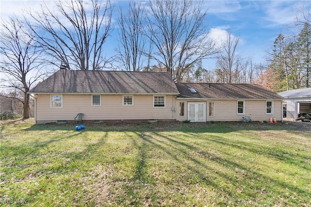 rear view of property with french doors and a yard