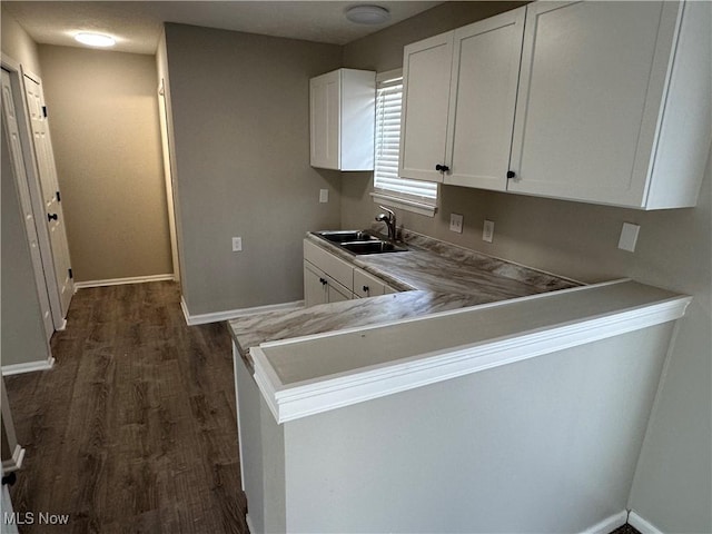 4225 E 93rd St, Cleveland, OH 44105 - kitchen featuring a sink, dark wood-style flooring, white cabinets, baseboards, and light countertops