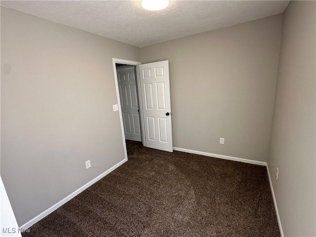 4225 E 93rd St, Cleveland, OH 44105 - spare room with dark colored carpet, baseboards, and a textured ceiling