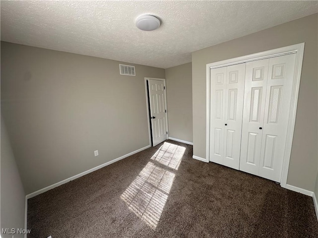 4225 E 93rd St, Cleveland, OH 44105 - unfurnished bedroom with dark carpet, a textured ceiling, a closet, and baseboards