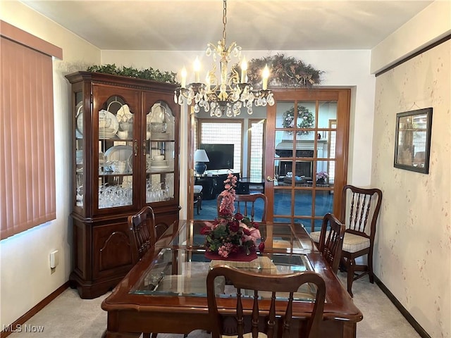dining room featuring a chandelier, baseboards, and carpet floors