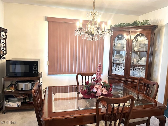 dining space featuring carpet and an inviting chandelier