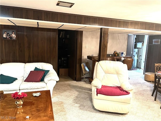 carpeted living area with wooden walls