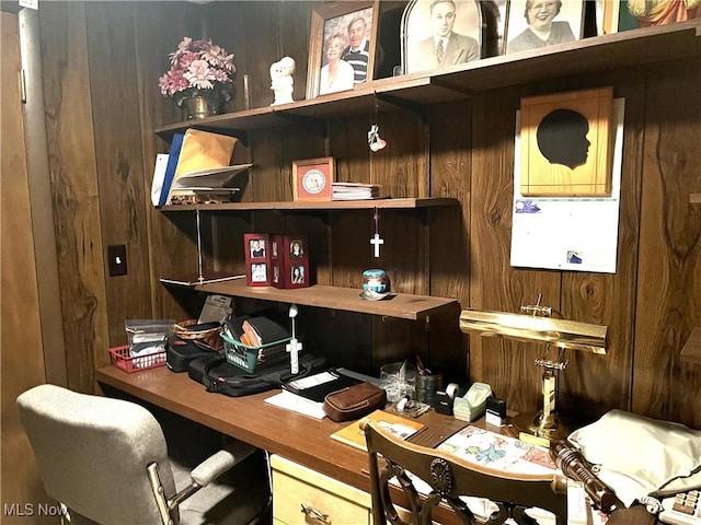 office area featuring built in desk and wooden walls