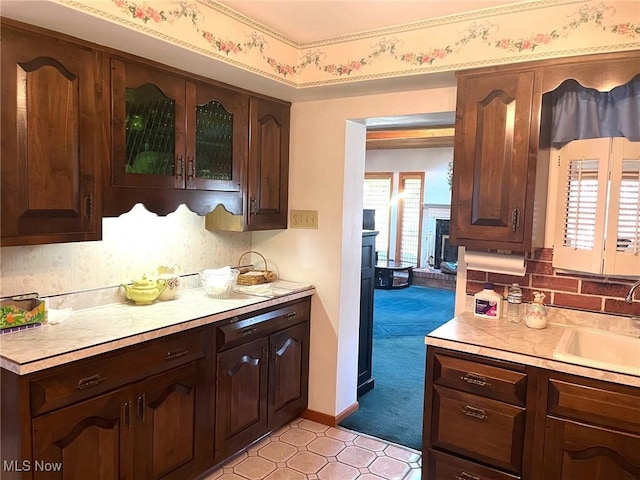kitchen with a sink, dark brown cabinets, and light countertops