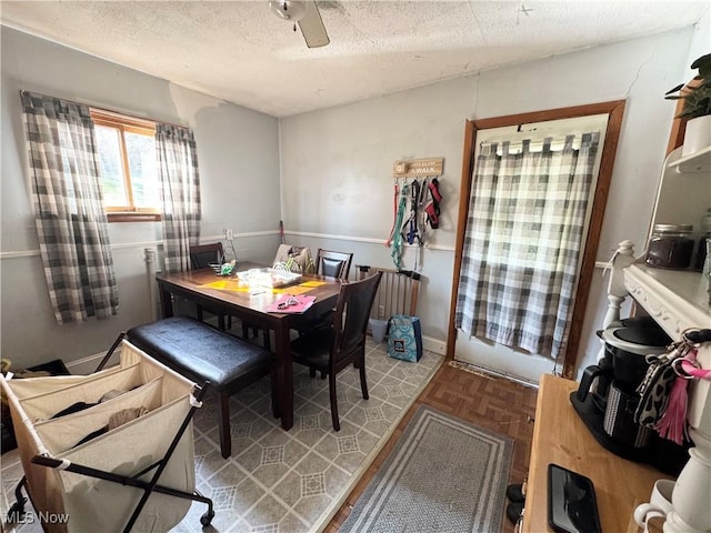 dining space featuring ceiling fan and a textured ceiling