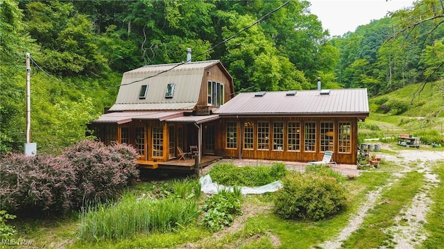 1000 Coon Fork Rd, Arnoldsburg, WV 25234 - back of property with a view of trees, a gambrel roof, a metal roof, and a porch