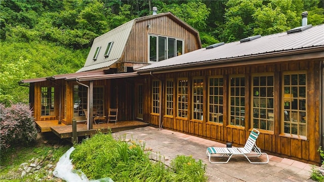 1000 Coon Fork Rd, Arnoldsburg, WV 25234 - back of property featuring a metal roof, a deck, a wooded view, and a patio