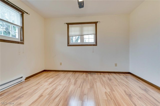 79 Windy Point Dr, Waterford, OH 45786 - empty room with baseboards, light wood finished floors, visible vents, and a baseboard radiator