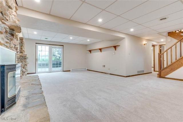 79 Windy Point Dr, Waterford, OH 45786 - unfurnished living room featuring visible vents, stairs, a baseboard heating unit, a multi sided fireplace, and light colored carpet
