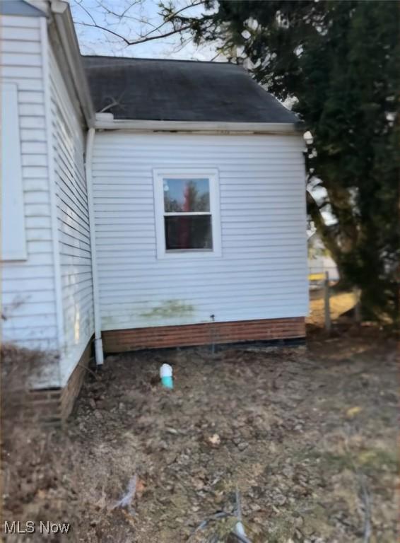 view of home's exterior with roof with shingles