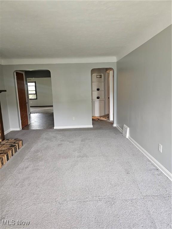 25100 Drakefield Ave, Euclid, OH 44132 - unfurnished living room with arched walkways and carpet
