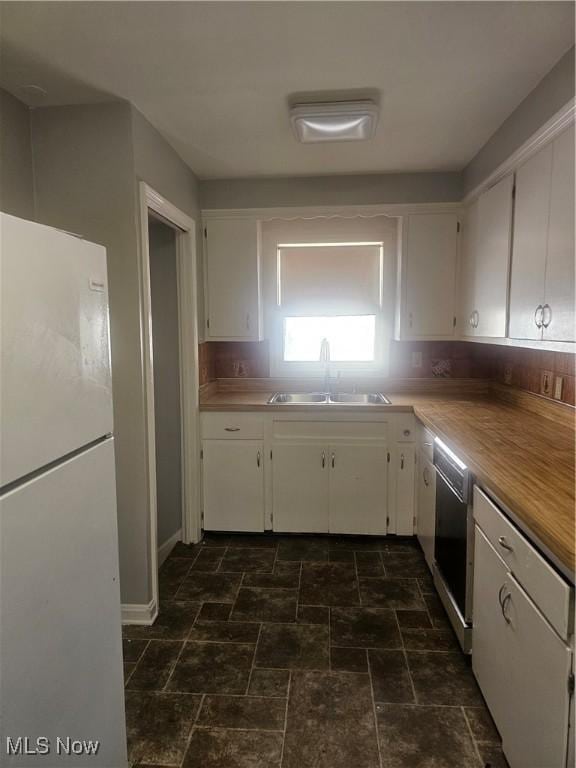 25100 Drakefield Ave, Euclid, OH 44132 - kitchen featuring freestanding refrigerator, white cabinets, dishwasher, and dark stone finish floors