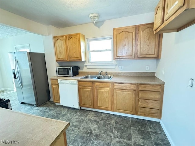 2106 17th St SW, Akron, OH 44314 - kitchen with baseboards, a textured ceiling, a sink, and stainless steel appliances