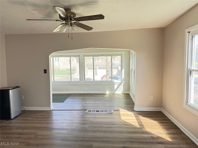 2106 17th St SW, Akron, OH 44314 - unfurnished room featuring arched walkways, a healthy amount of sunlight, and wood finished floors